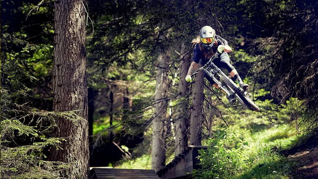 Mountainbiker auf einer Holzrampe im Wald