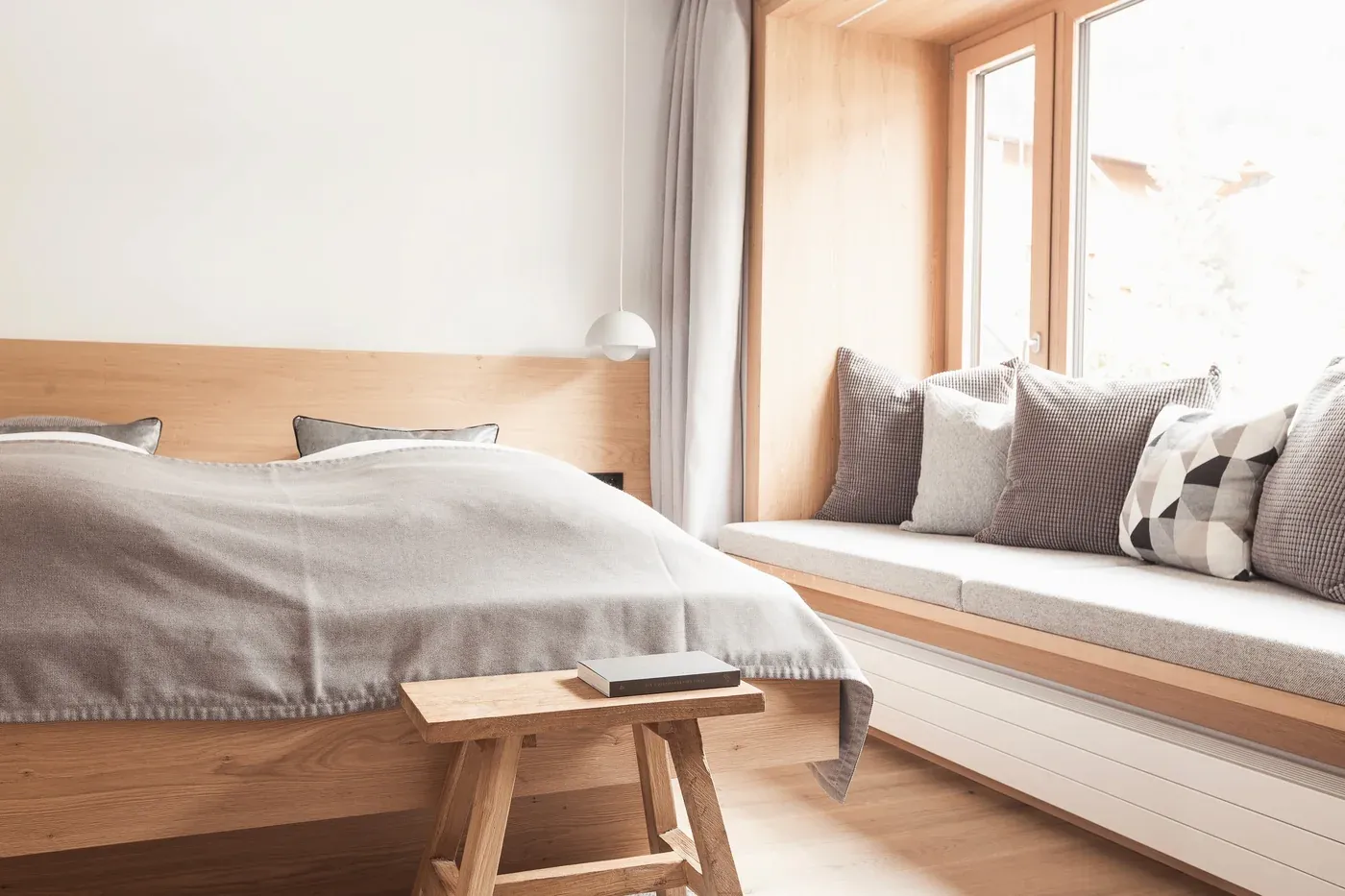 Zimmer Modern Nord mit Doppelbett und Sitzbank am Fenster