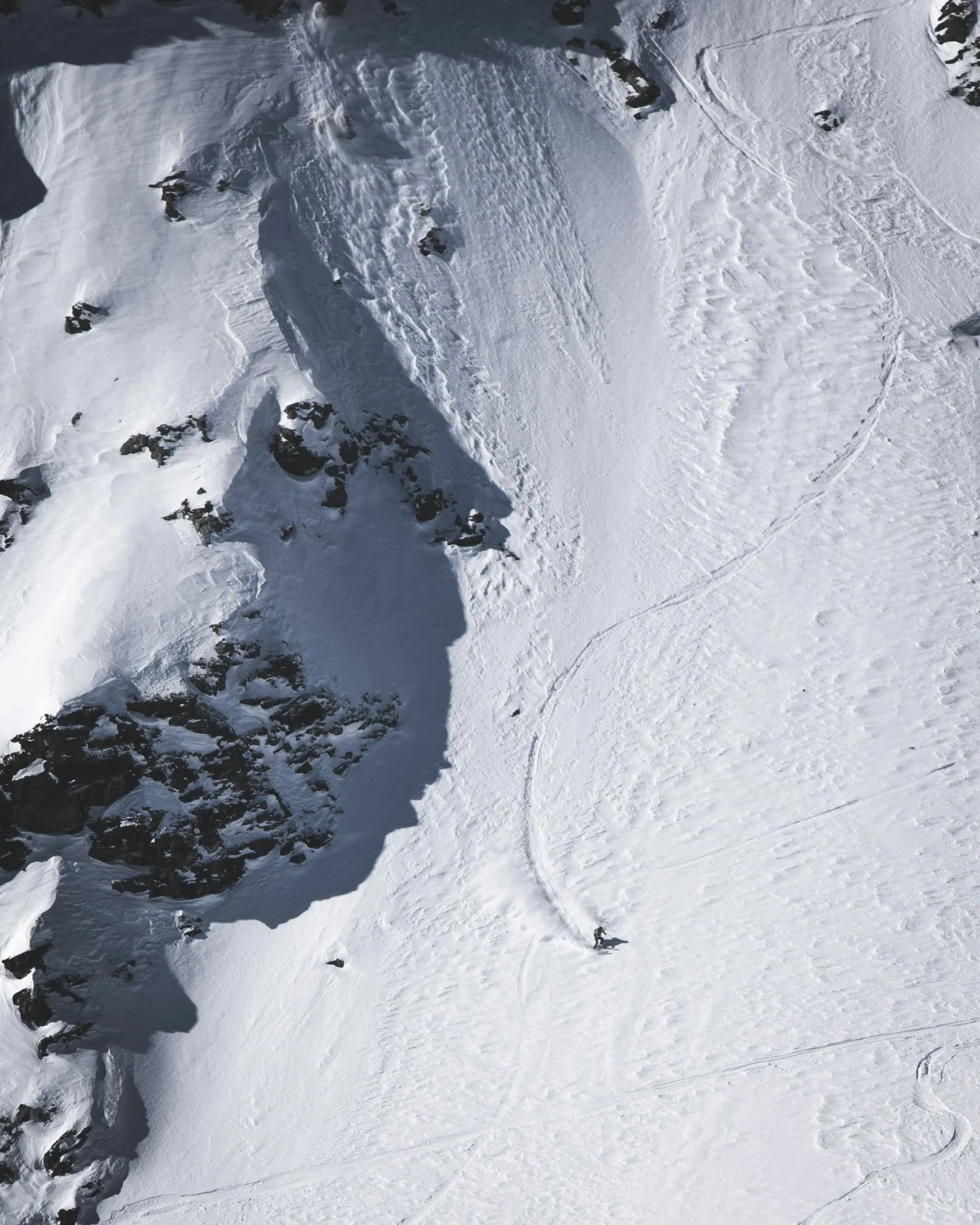 Blick von oben auf einen Hang mit frischen Schwüngen im Schnee