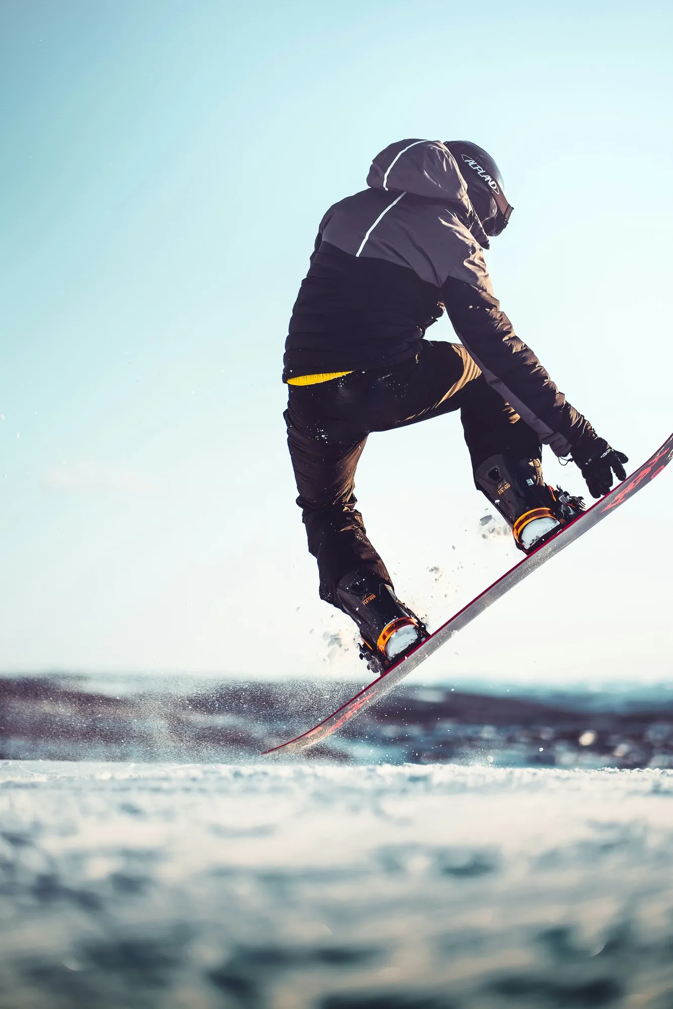 Snowboarder in der Luft über der Piste