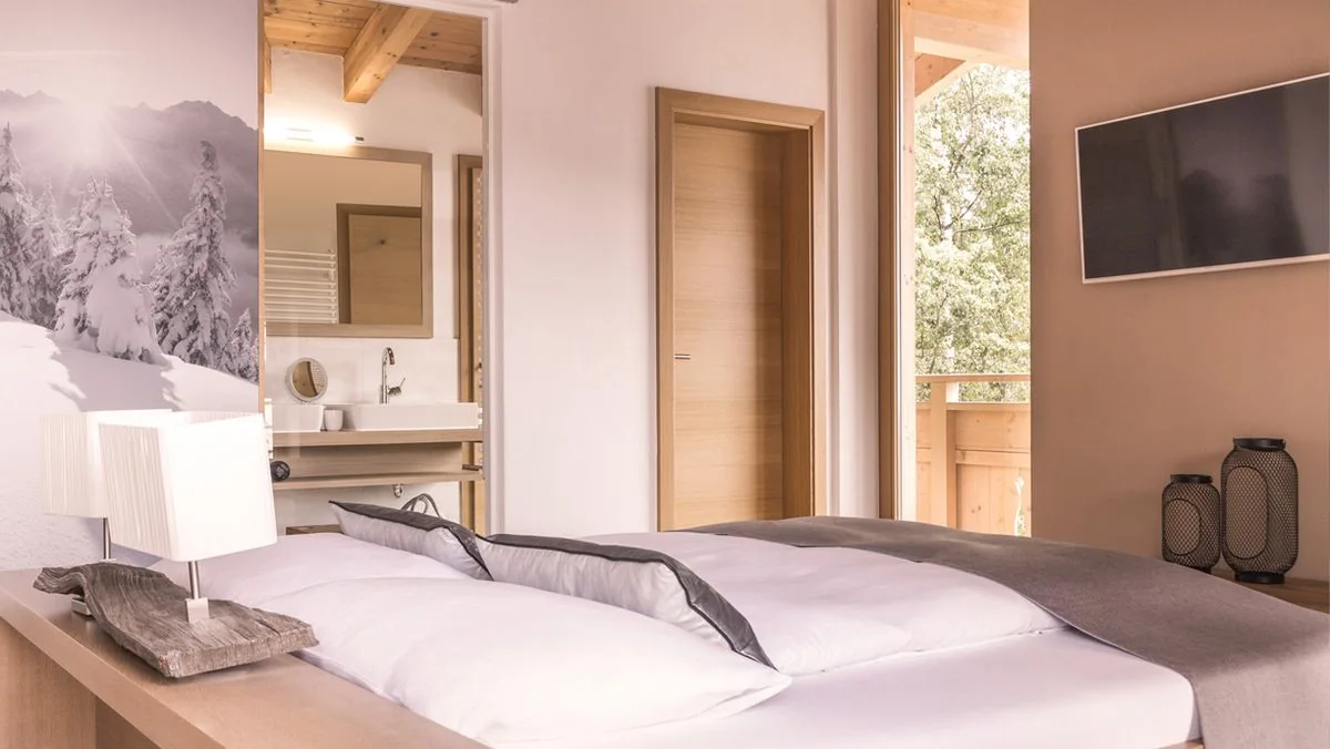 Schlafraum der Familien Suite mit Blick ins Bad und auf den Balkon