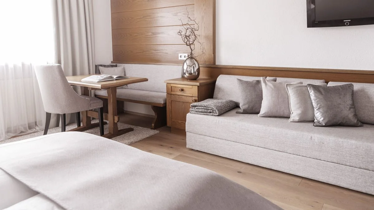 Runder Holztisch mit Stuhl neben dem Bett